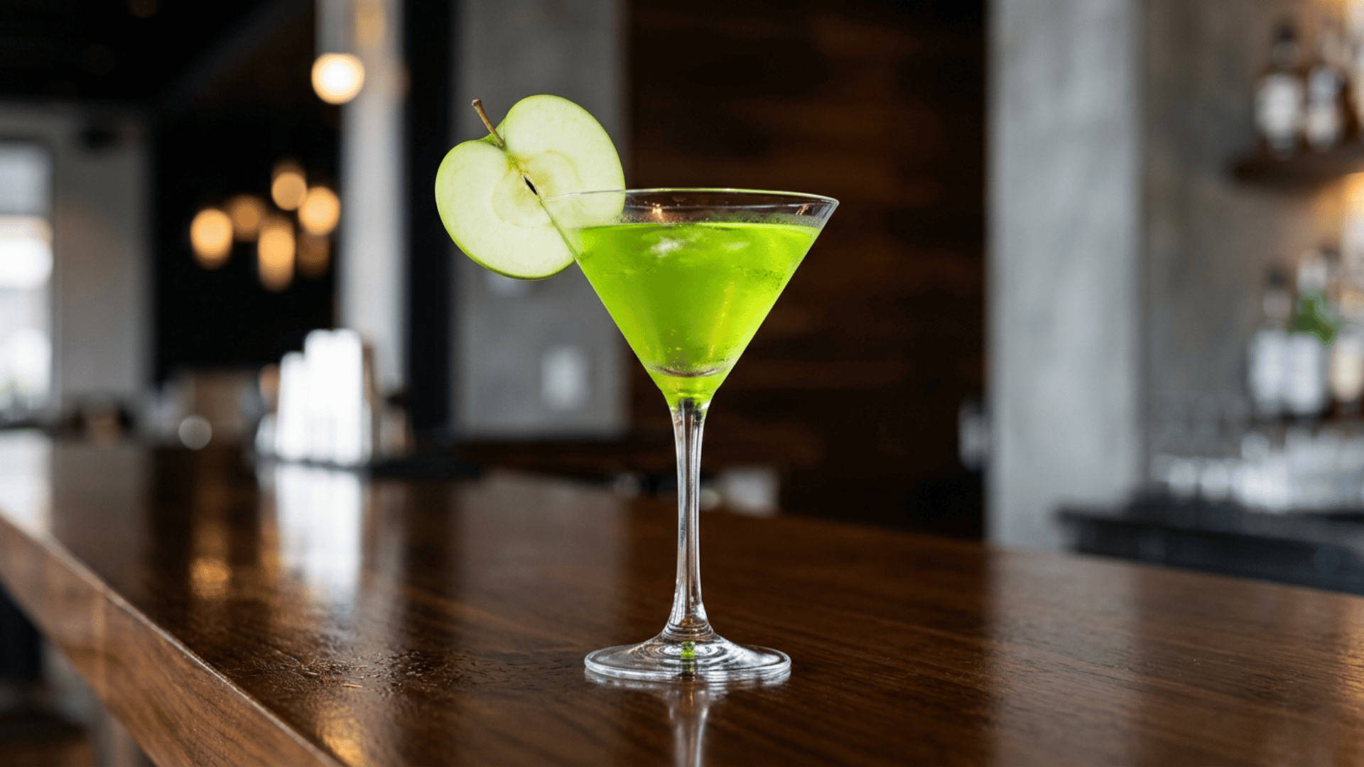 Green Appletini cocktail in a martini glass with apple slice garnish.