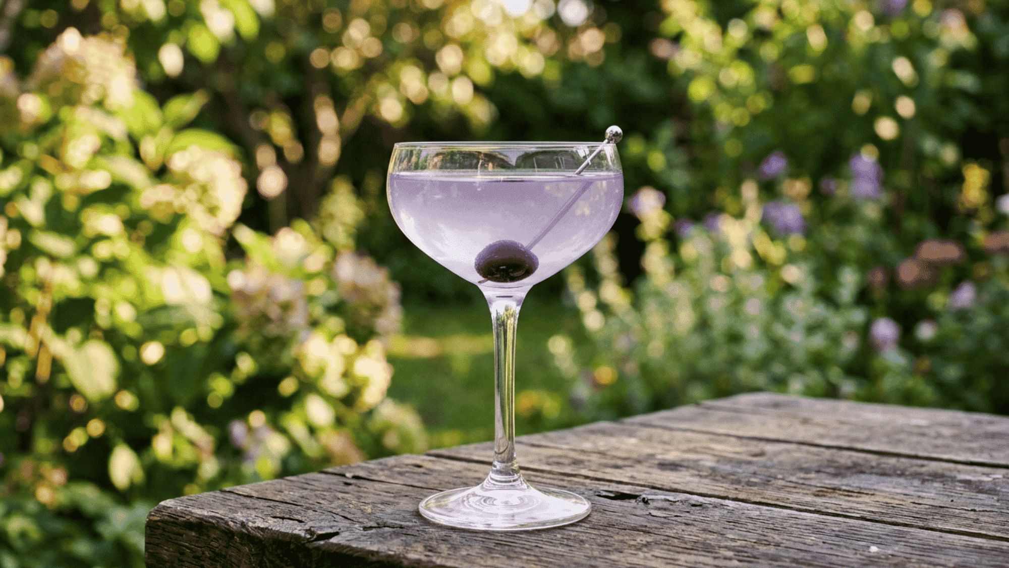 Aviation cocktail with pale lavender color and cherry in a coupe glass