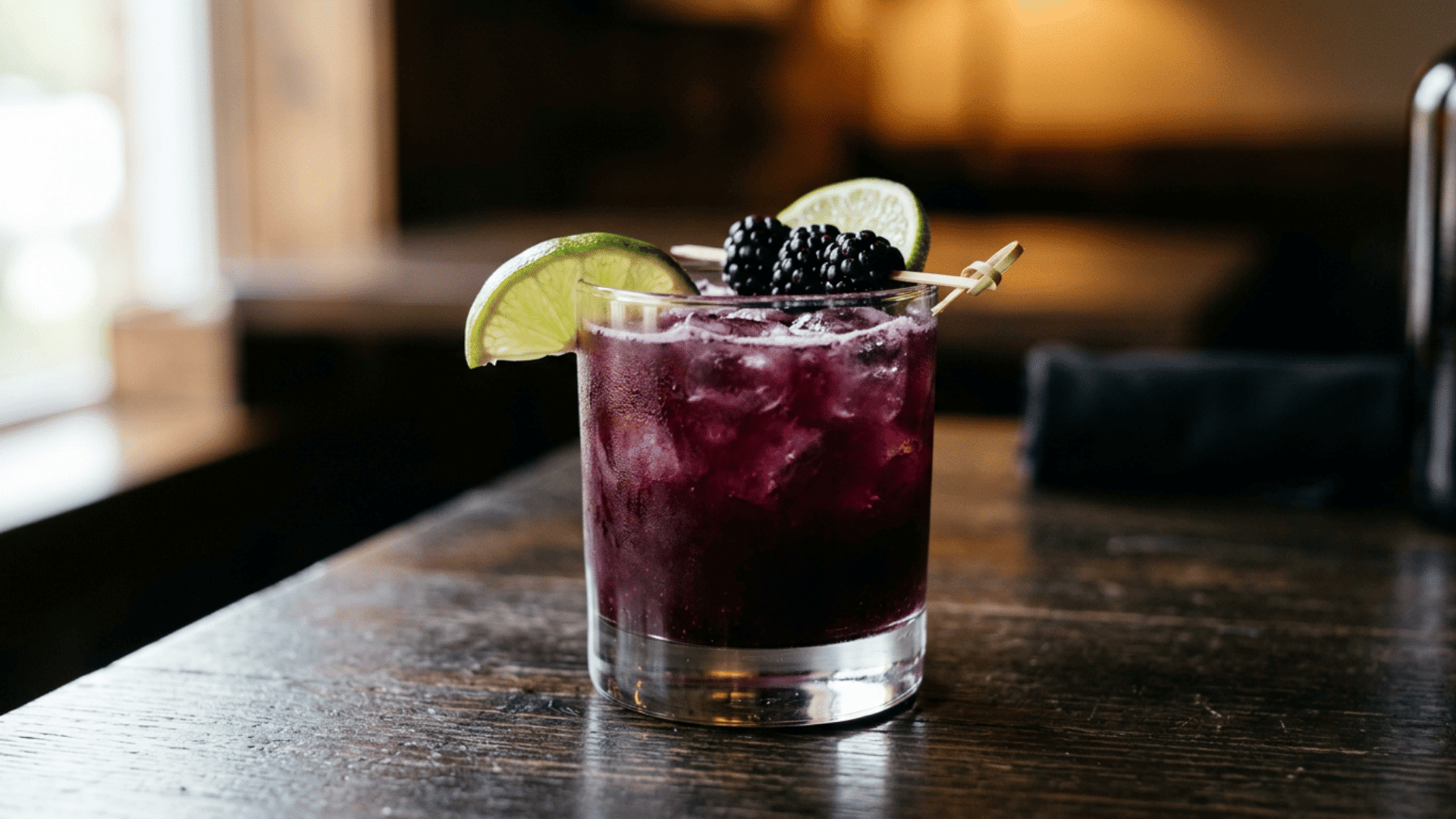 Blackberry lime margarita with deep purple color and blackberry garnish