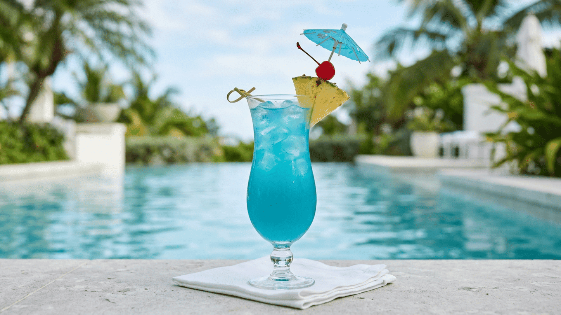 Blue Hawaiian cocktail in a curved glass with pineapple and cherry garnish