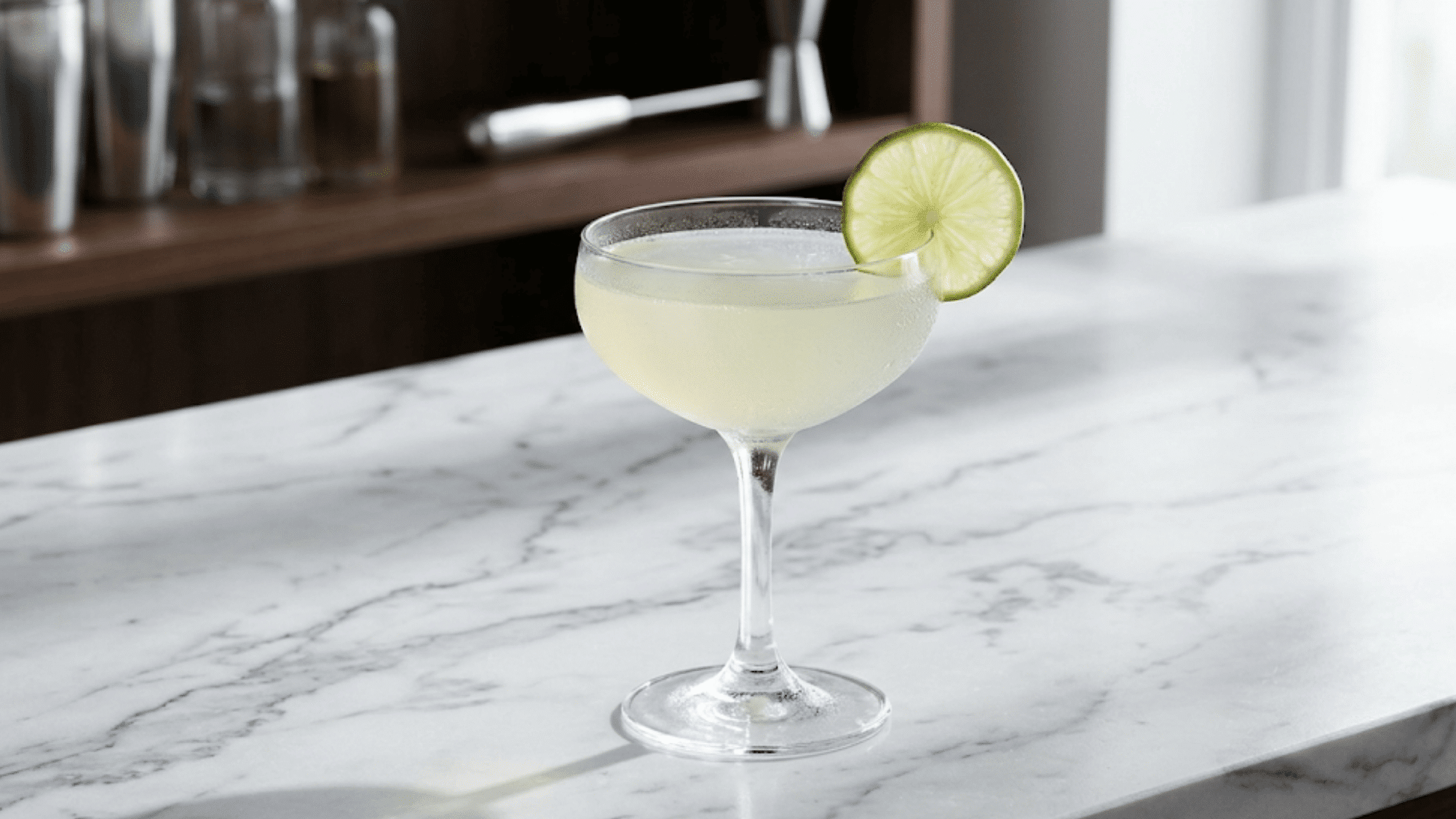 Classic Daiquiri in a coupe glass with pale lime color and citrus garnish.