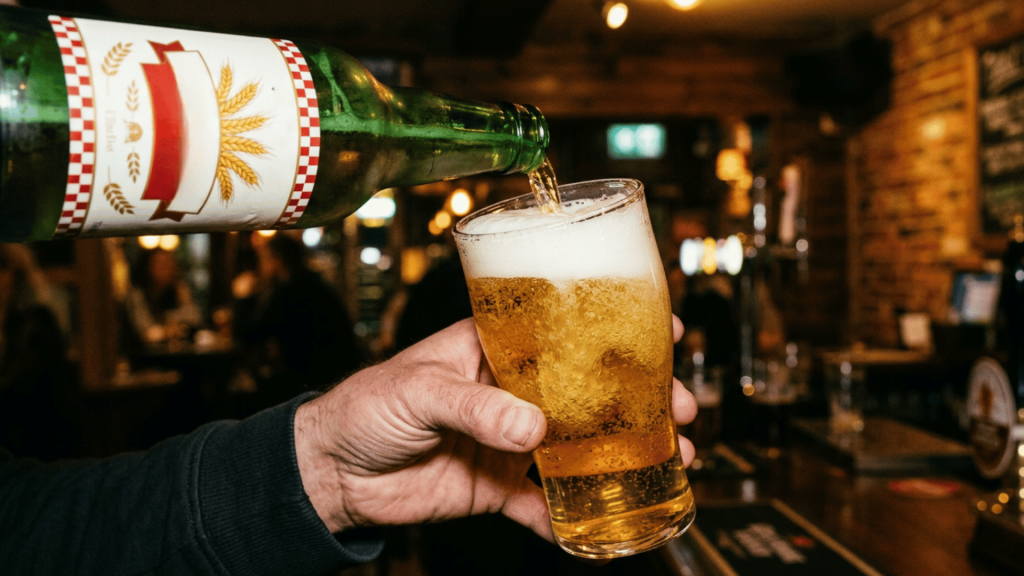 person putting beer in glass.