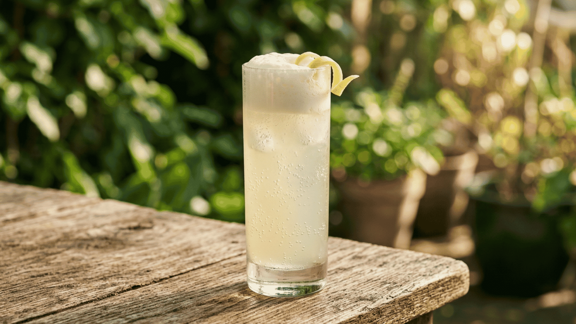 Gin Fizz with lemon, foam, and soda bubbles in a highball glass