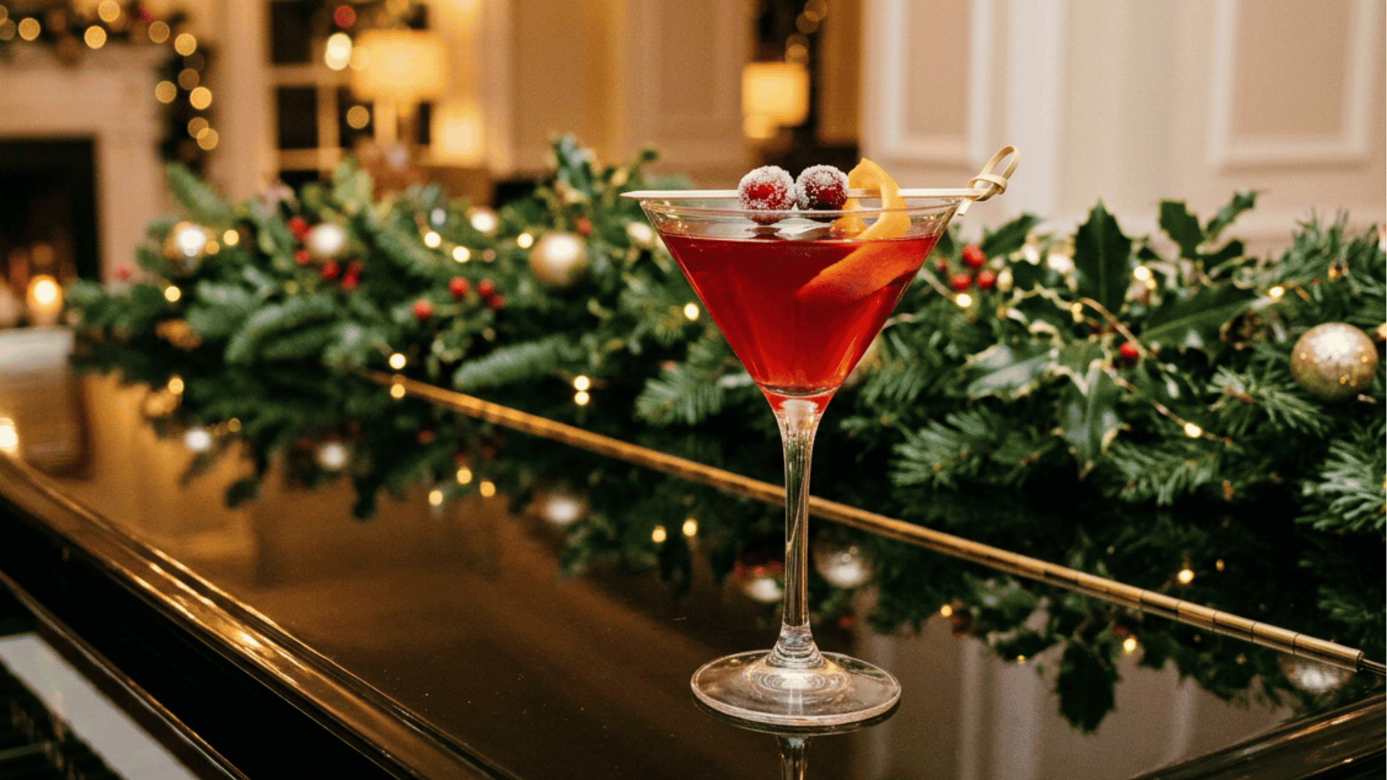 Holiday Cosmopolitan on a grand piano with festive greenery and warm holiday lights