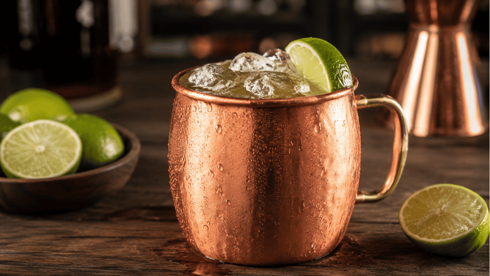 Kentucky Mule in a copper mug with ice and lime on a wooden bar
