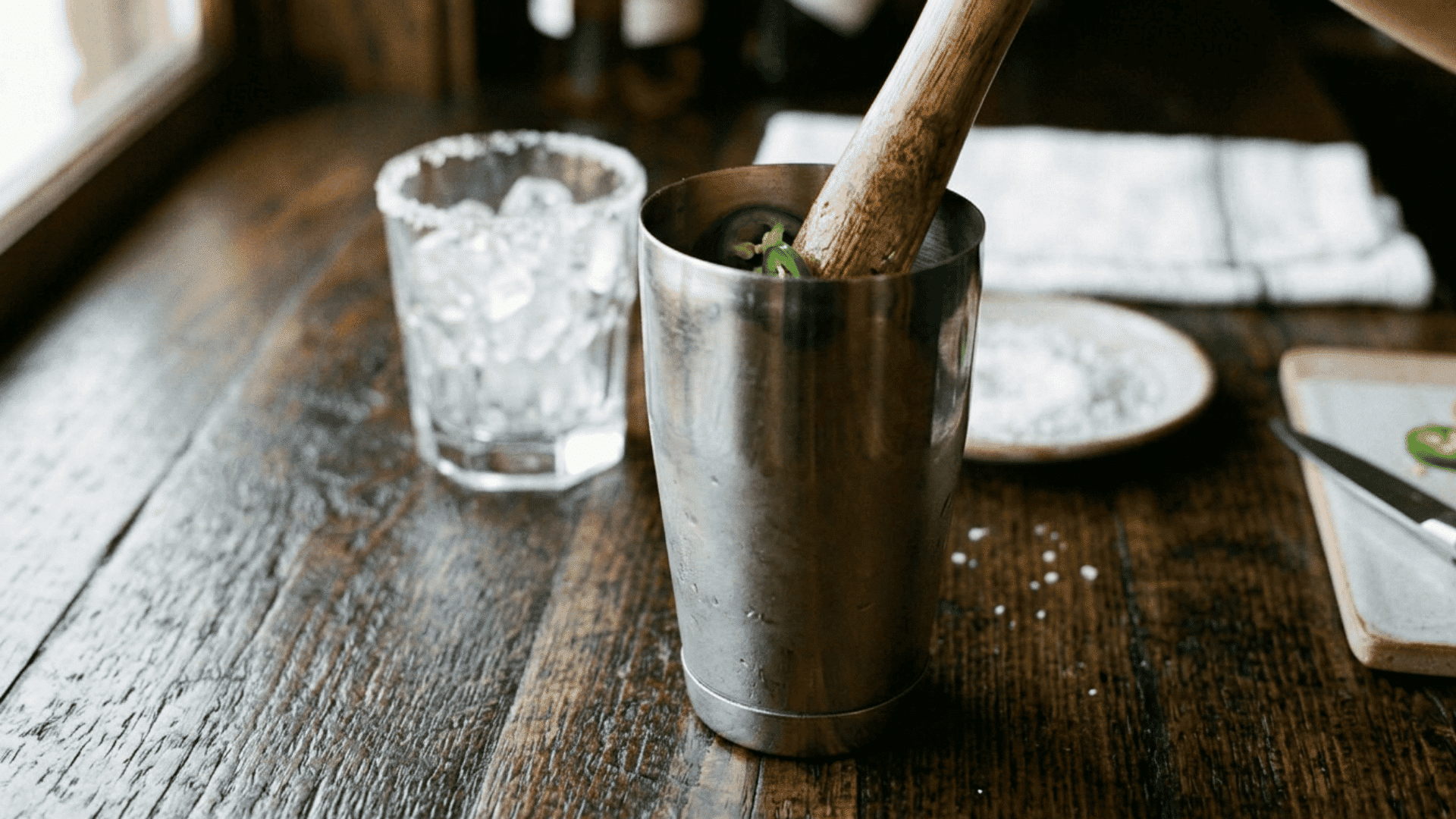 Frosted cocktail shaker being shaken with fresh ice