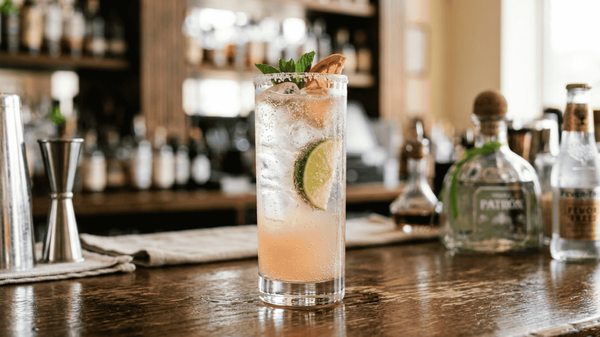 Paloma cocktail with lime and grapefruit garnish on a bright bar counter