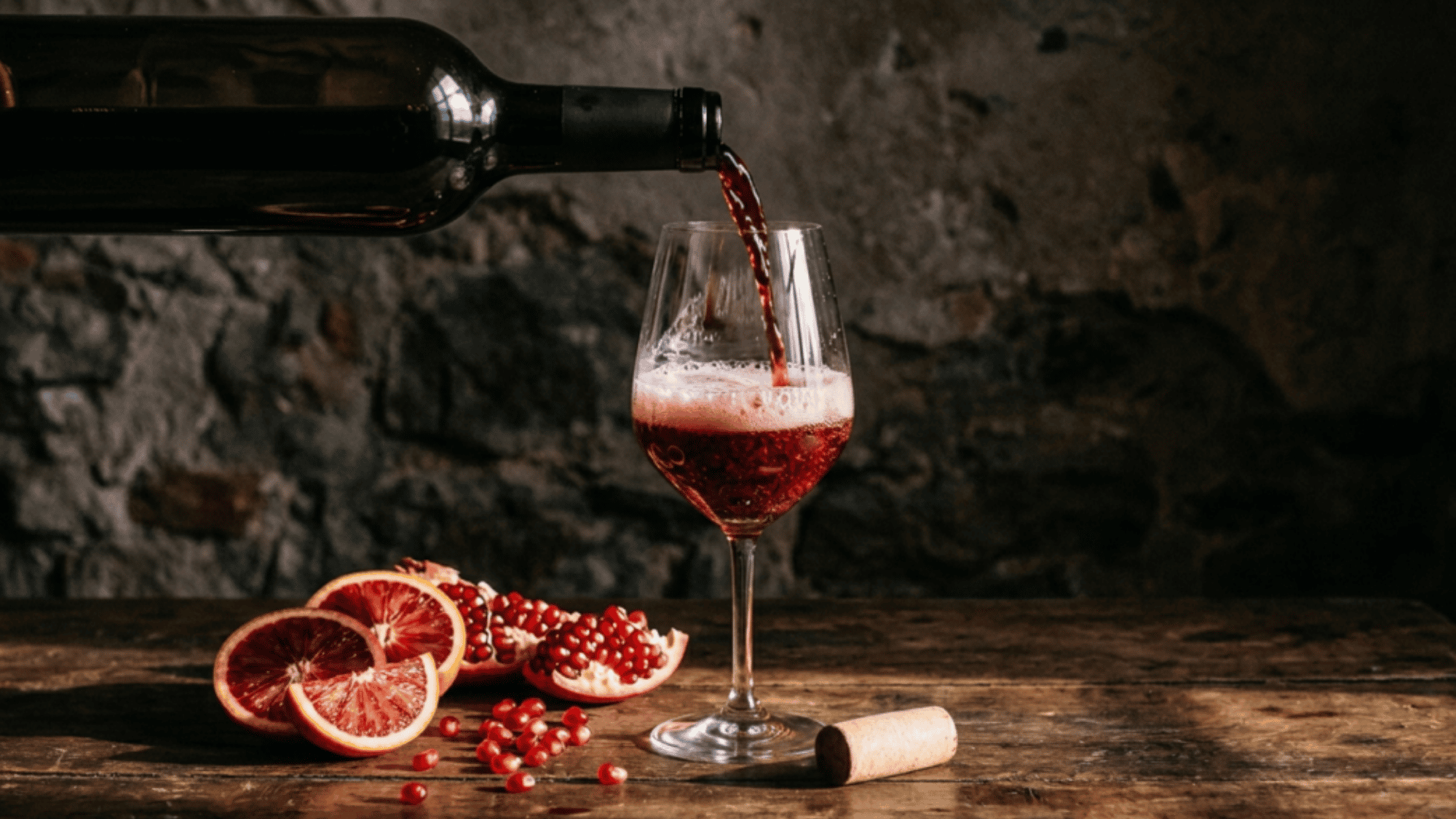 Deep red wine being poured smoothly into a clear wine glass.