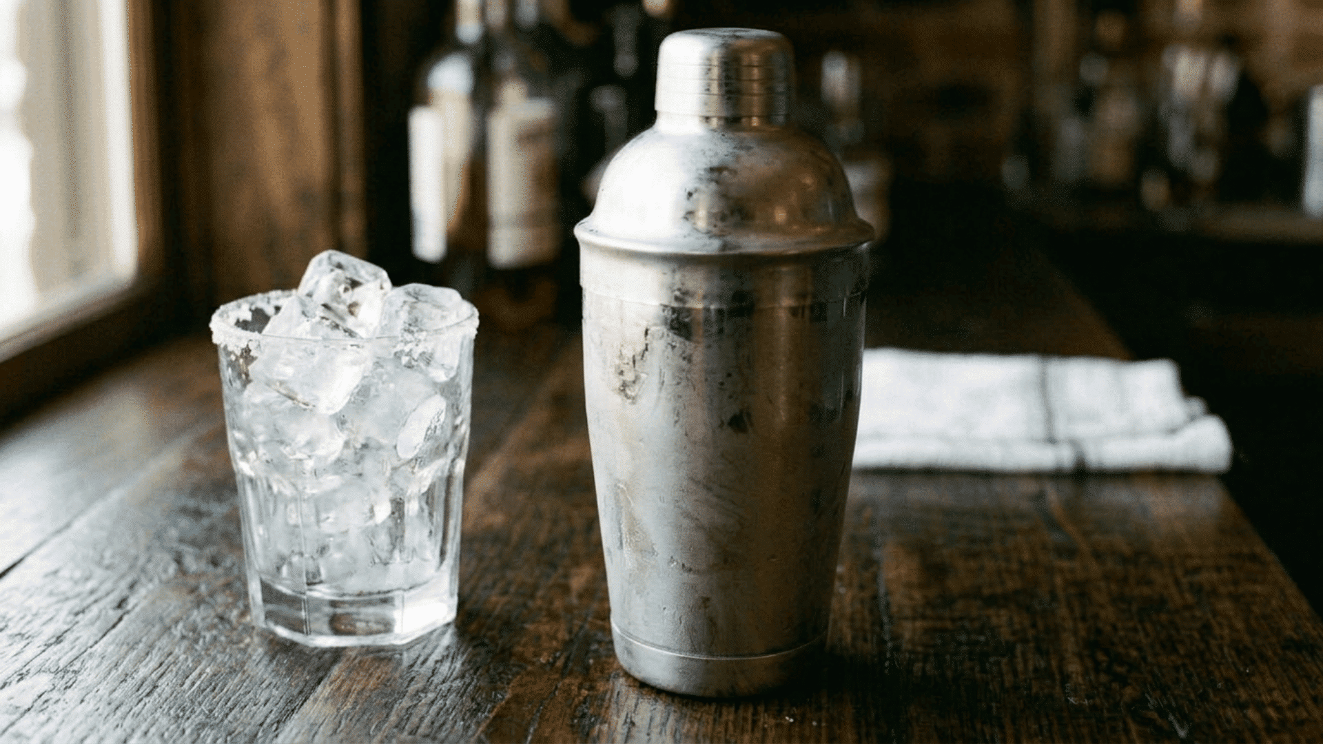 Frosted cocktail shaker being shaken with fresh ice