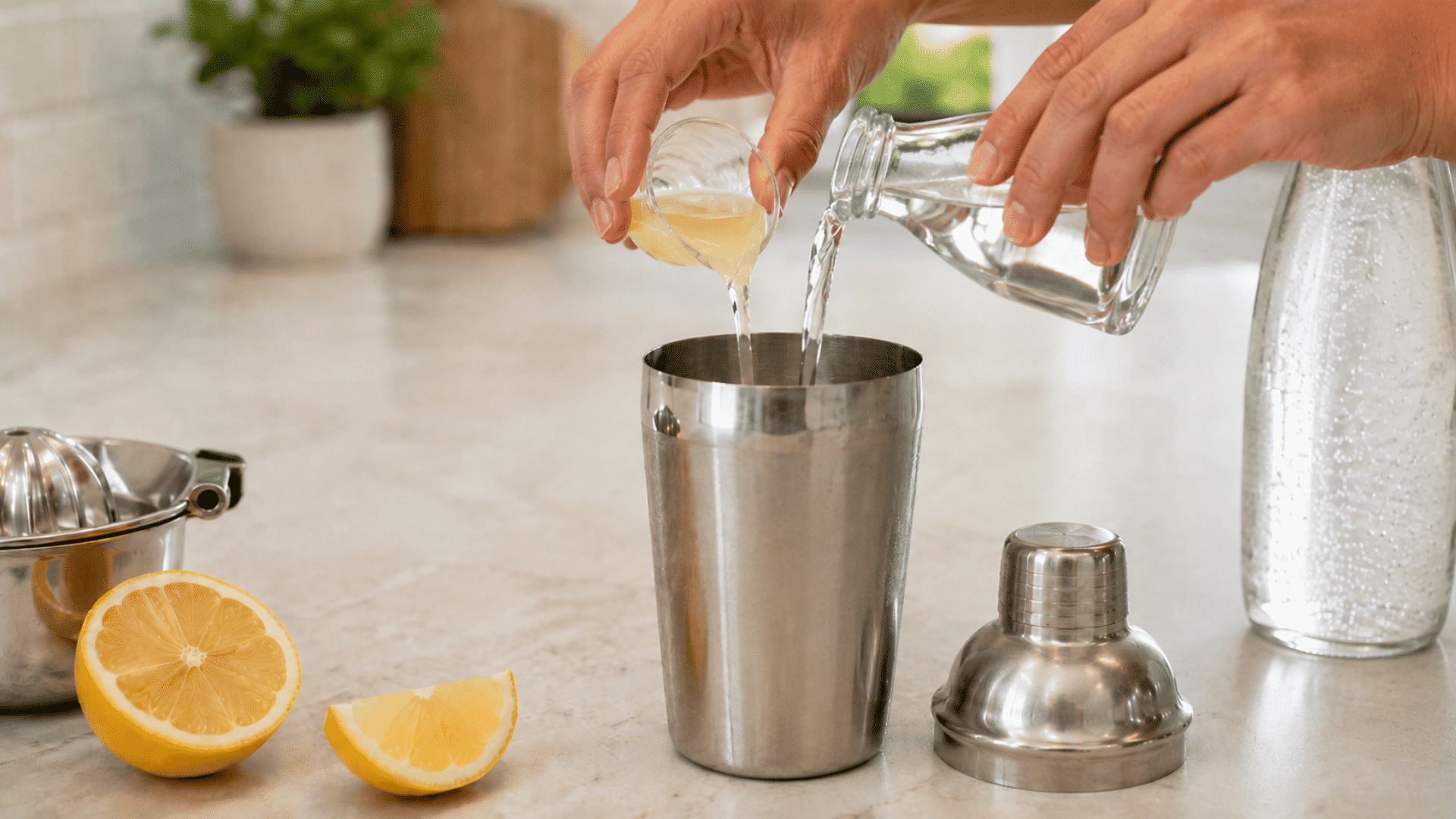 Hands pouring lemon juice and clear spirits into a steel cocktail shaker.