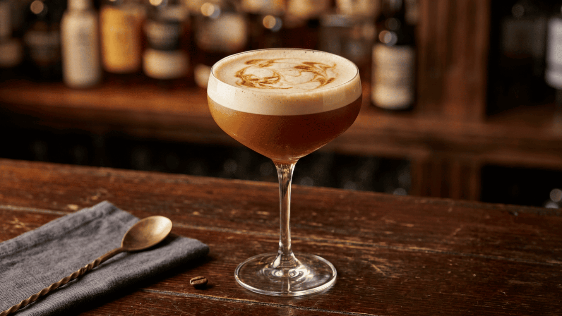 Coffee Mezcal Sour with foam top and bitters in a coupe glass