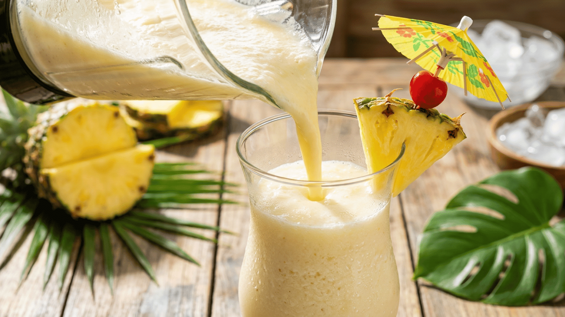 freshly blended piña colada being poured into a garnished glass.