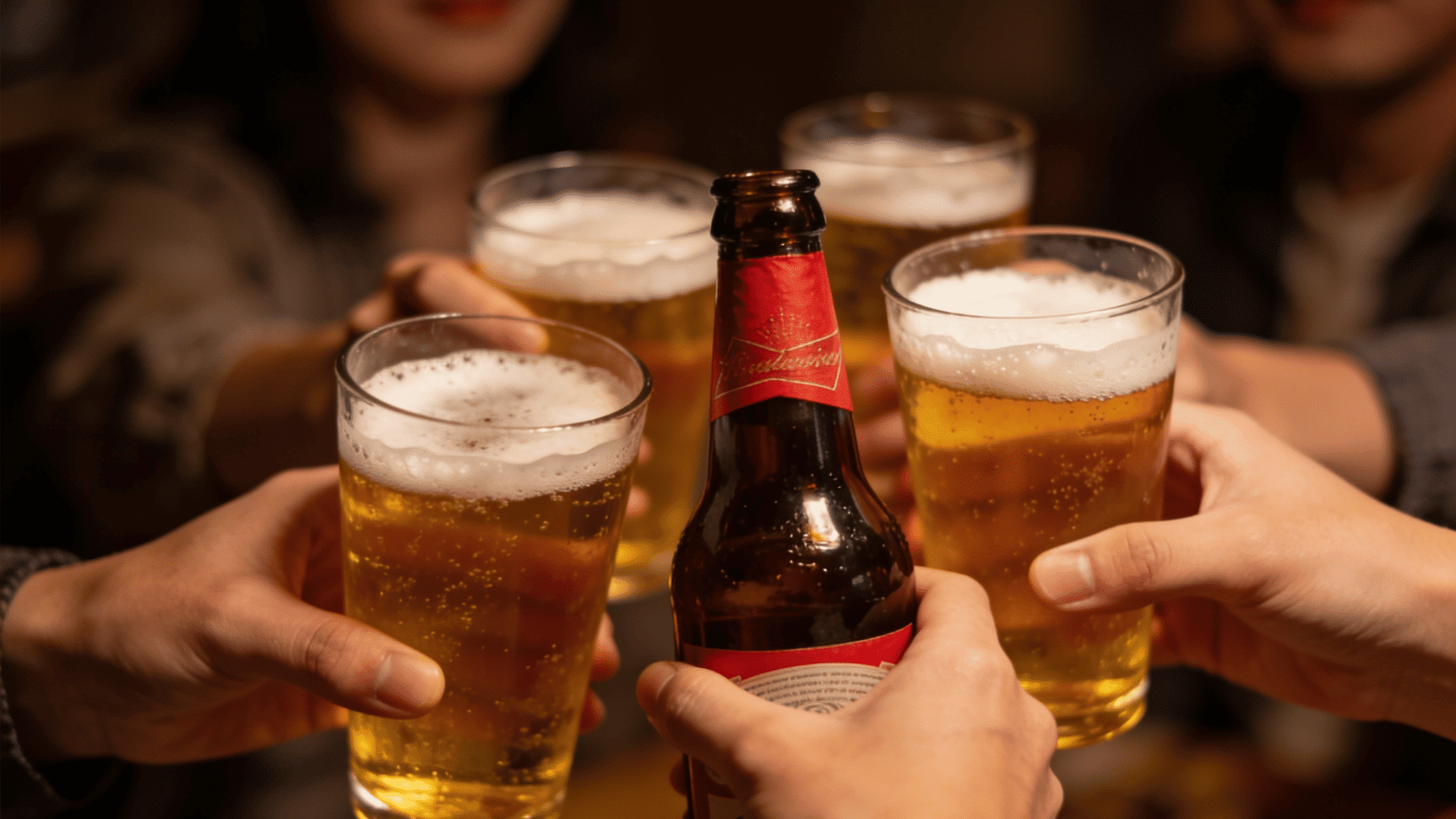 friends raising glasses of beer together at a social gathering
