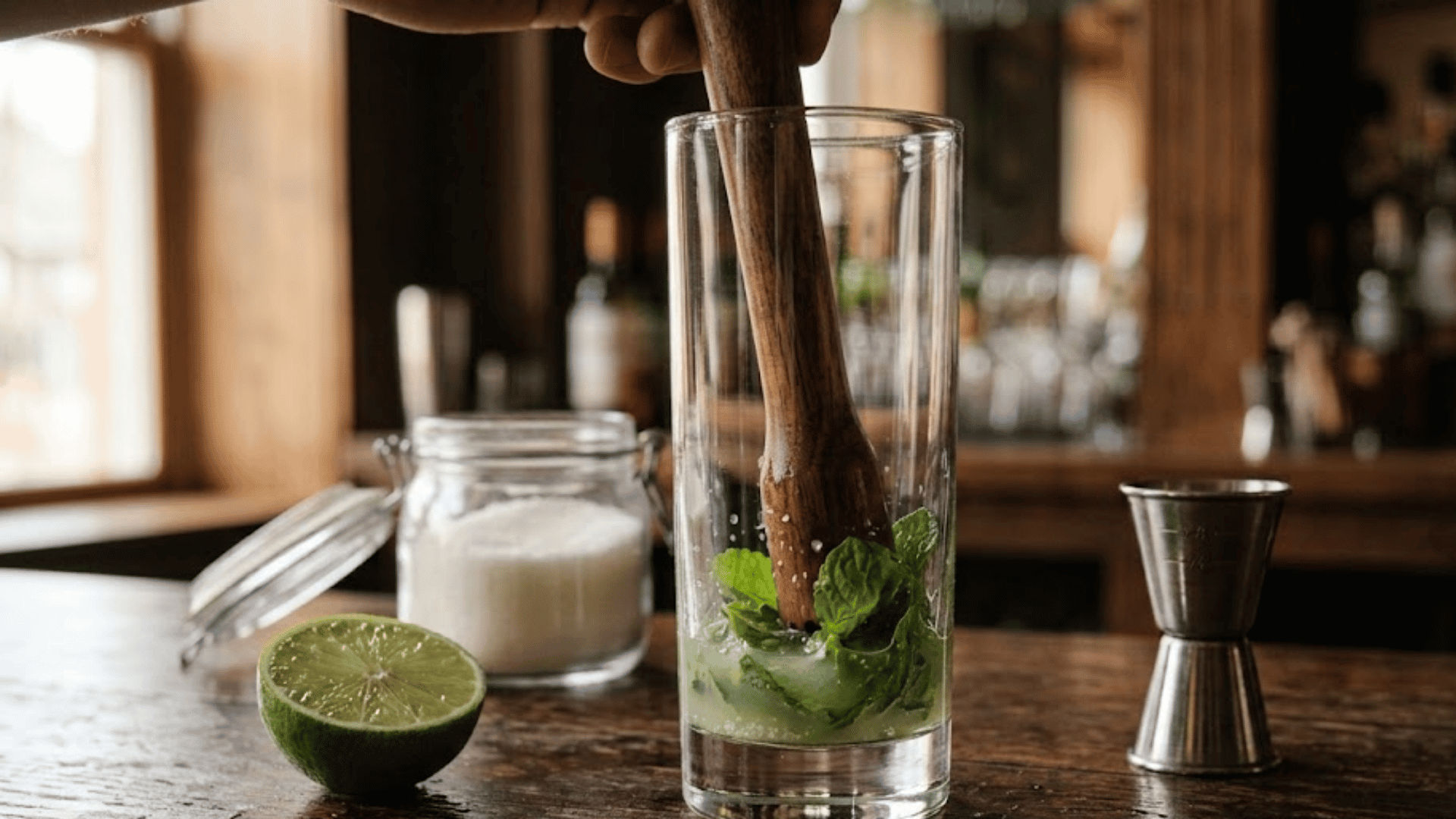 mint leaves gently muddled with lime juice in a tall glass
