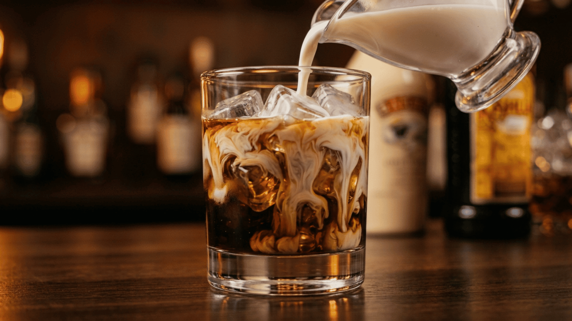 cream pouring into a dark white russian base over ice, creating smooth marbled swirls