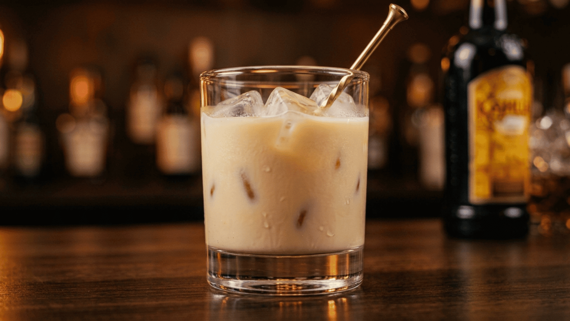 finished white russian cocktail with ice and stirrer on a warm, softly lit bar counter