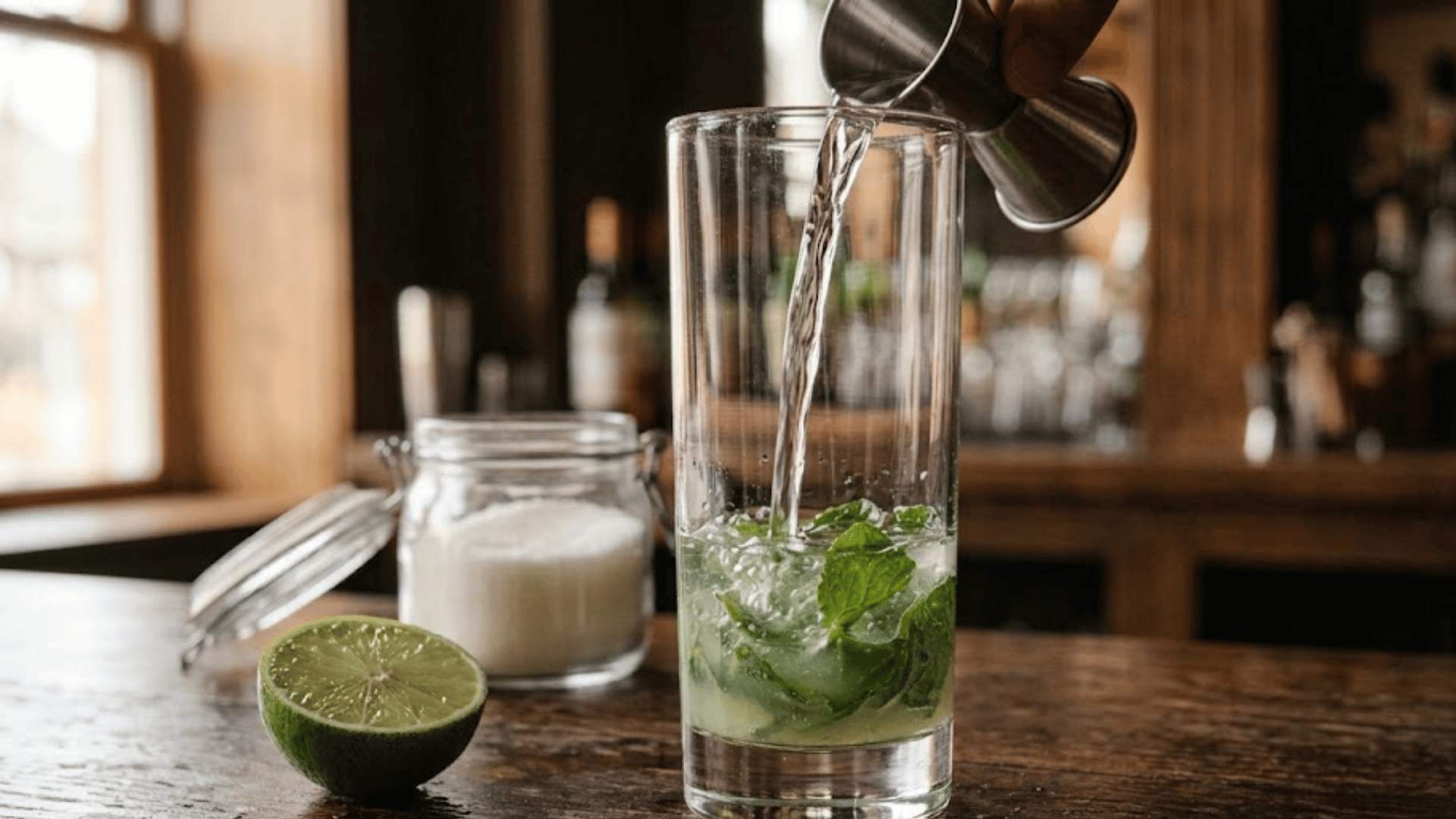 white rum poured over muddled mint and lime in a glass
