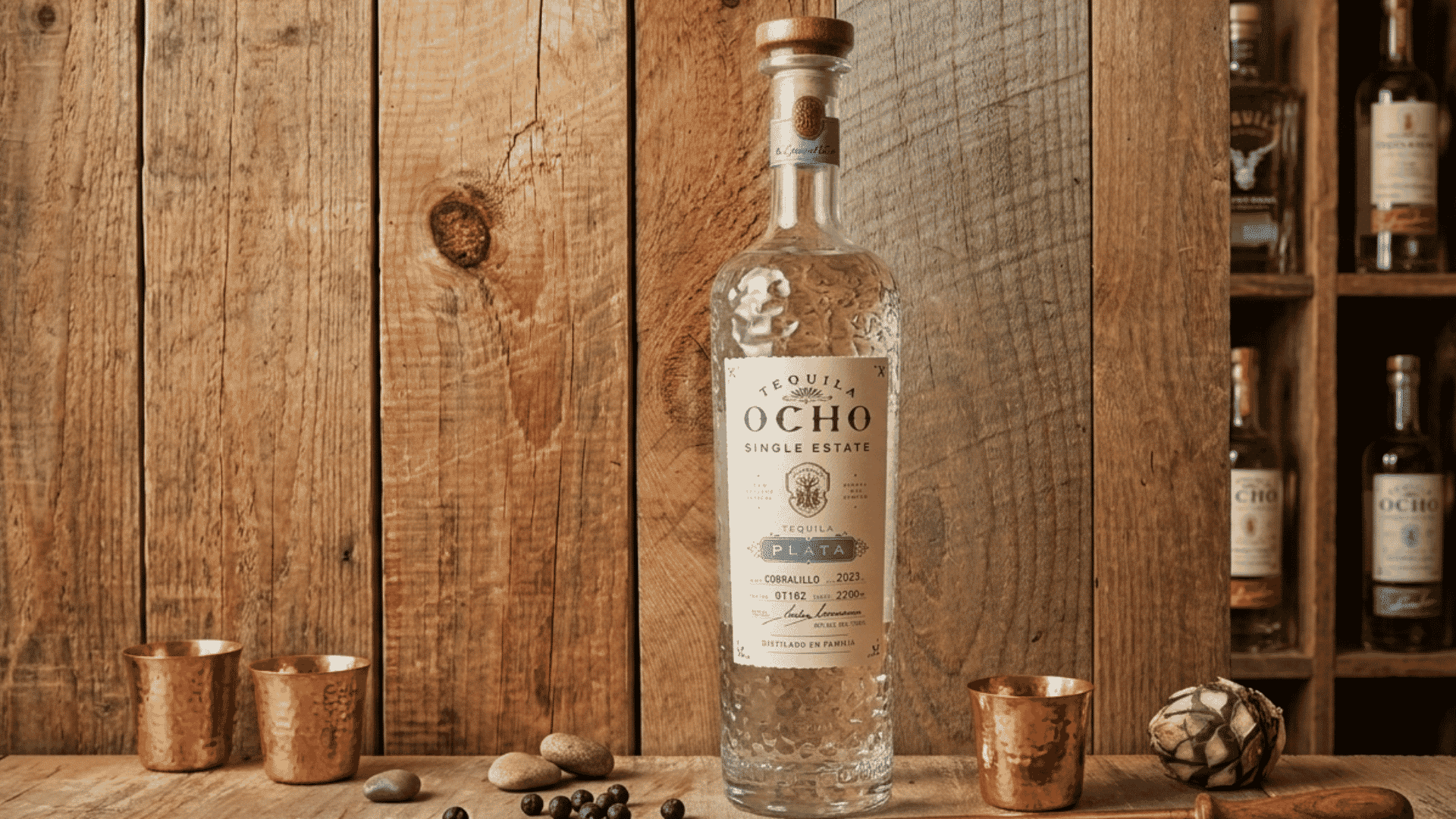 Tequila Ocho Plata bottle displayed against a rustic wooden bar backdrop