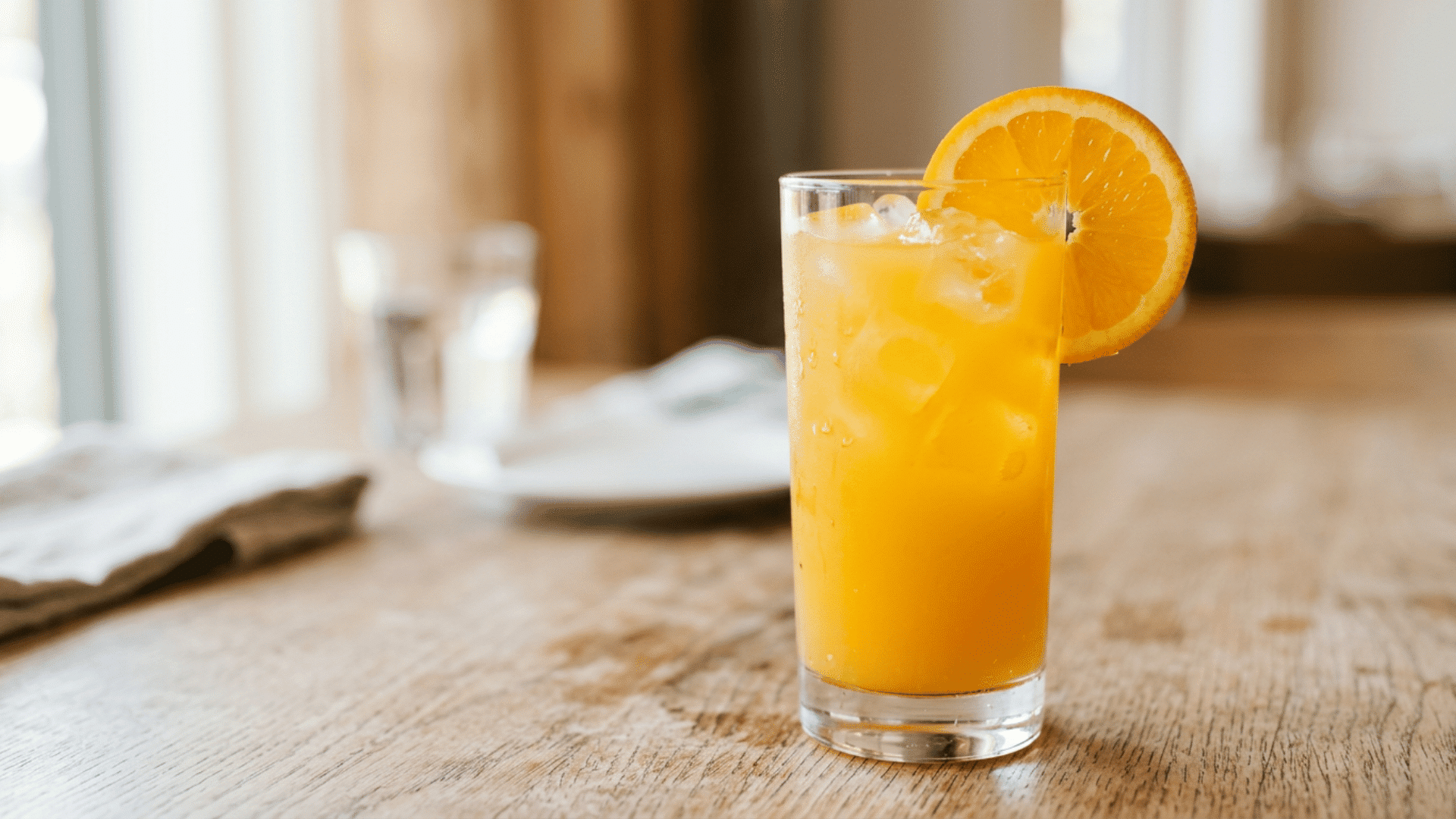 Finished Screwdriver cocktail with ice and fresh orange slice garnish on a highball glass